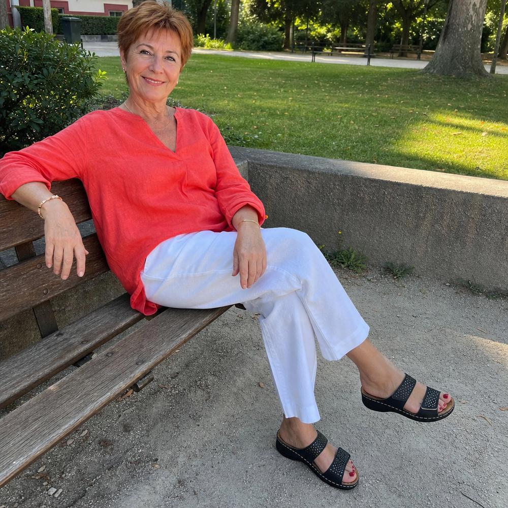 Cliente portant la sandale Balea noire sur un banc de parc